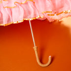Pink umbrella with gold trim on a red background